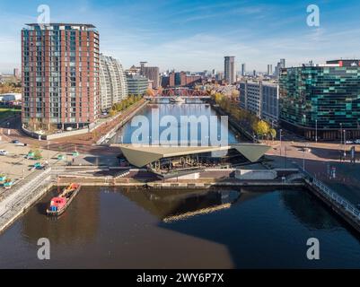 Drohnenfoto am North Basin mit Blick auf Huron & Eerie Basin in Salford Quays, vorbei an Alchemist, 94 The Quays, BUPA, Detroit Bridge & NV Building Stockfoto