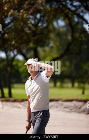 Mann im Freien und auf der Suche nach Ball im Golfspiel auf dem Platz, um die Action im Sport oder im Wettkampf zu sehen. Athlet, suchen und finden Sie Ziel für Training auf dem Rasen Stockfoto