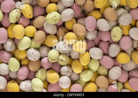 Flaches Lagen von pastellfarbenen, zuckerüberzogenen Schokoladen-Mini-Eiern Stockfoto