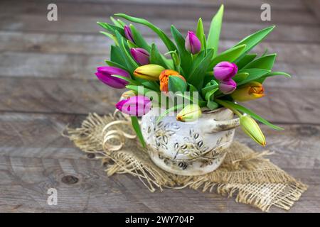Bunte Tulpen in einer Vase - alter hölzerner Hintergrund Stockfoto