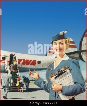 Das goldene Zeitalter der Fliegerei 1950 mit einer Air Hostess in TWA-Uniform, die Passagiere an Bord des Flugzeugs TWA Lockheed Super Constellation an einem klaren, sonnigen Tag begrüßt. Der Kapitän der Fluggesellschaft begrüßt ein Kind an Bord. Werbeaktion Pressemagazin. Stockfoto