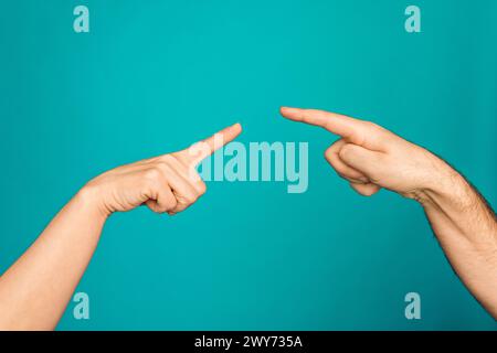 Foto von zwei männlichen weiblichen Armen, die sich gegenseitig berühren Finger isolierter türkisfarbener Hintergrund Stockfoto