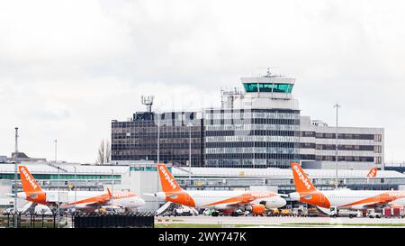 Drei Easyjet Airbus A320-214 Flugzeuge, die am 4. April 2024 in einem Terminal unter dem Kontrollturm am Flughafen Manchester abgebildet waren. Stockfoto