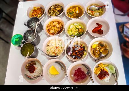 Teller mit mehreren essbaren Speisen, traditionelles malaysisches Essen, unter den Gerichten sind Nasi Lemak, Me Kari, Cendol, tandori Huhn, Pulut mangga, nasi Stockfoto