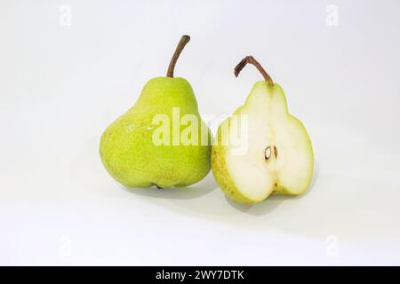 Eine köstliche Birne isoliert. Eine ganze grüne Birne und eine halbe Frucht auf weißem Hintergrund. Birnenschicht. Mit Beschneidungspfad. Volle Schärfentiefe. Stockfoto
