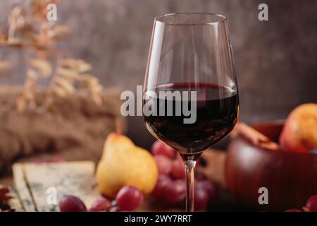 Herbstpicknick mit Wein- und Käseplatte, Früchten und trockenen Blättern Stockfoto
