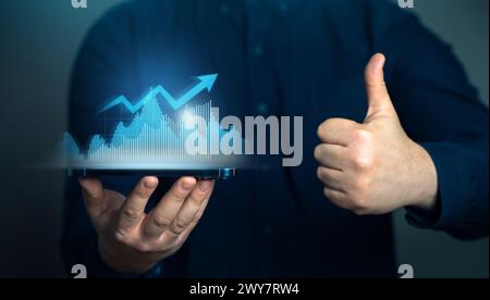 Geschäftsmann zeigt erfolgreiches Wachstum und Daumen hoch. Erreichen Sie die Ziele für das Wachstum des Geschäftsumsatzes. Wachstum der Indikatoren, optimistische Prognosen. Aktienkurse, Stockfoto