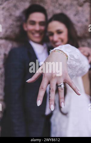 Die Hände des frisch vermählten Paares zeigen Eheringe und konzentrieren sich auf das Symbol der Liebe und des Engagements Stockfoto