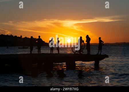 Salvador, Bahia, Brasilien - 09. März 2019: Jugendliche in Silhouette werden zusammen gesehen und genießen den Sonnenuntergang von der Spitze der Crush Bridge in der Stockfoto