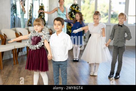 Tween Junge und Mädchen spielen Walzer während der Weihnachtsfeier in der Schule Stockfoto