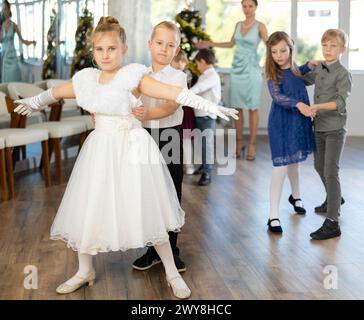 Jugendliche in eleganten Outfits üben im Weihnachtsstudio Partnertanz Stockfoto