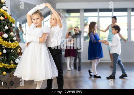 Tween Junge und Mädchen spielen Walzer während der Weihnachtsfeier in der Schule Stockfoto