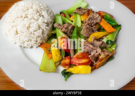 Rühren Sie das Rindfleisch mit süßen Paprika, Pak Choy und Reis. Scharfes Rindfleisch mit Gemüse. Asiatische Küche. Draufsicht. Farbenfrohe Nahaufnahme zum Pfannenbraten Stockfoto