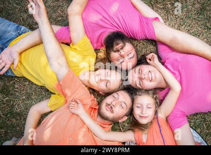 Glückliche Familie liegt mit geschlossenen Augen auf dem Gras Stockfoto