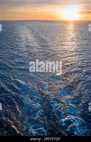 Direkte Schiffspur auf hoher See bei Sonnenuntergang Stockfoto