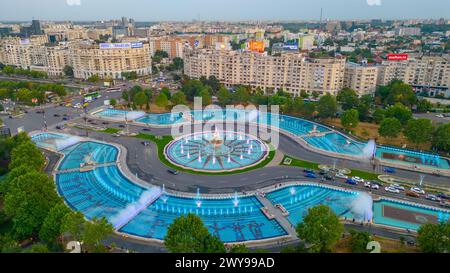 Bukarest, Rumänien, 21. August 2023: Panoramablick bei Sonnenuntergang auf einen Brunnen auf dem Unirii-Platz in Bukarest, Rumänien Stockfoto