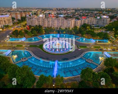 Bukarest, Rumänien, 21. August 2023: Panoramablick bei Sonnenuntergang auf einen Brunnen auf dem Unirii-Platz in Bukarest, Rumänien Stockfoto