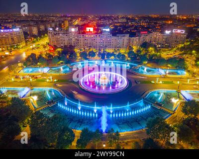 Bukarest, Rumänien, 21. August 2023: Panoramablick bei Sonnenuntergang auf einen Brunnen auf dem Unirii-Platz in Bukarest, Rumänien Stockfoto