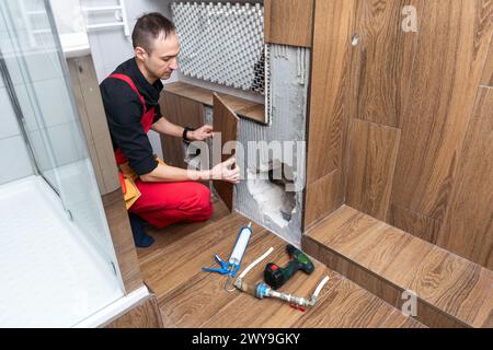 Bauarbeiter mit Wasserwaage arbeitet an Renovierungen Stockfoto