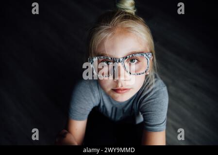 Nahporträt eines jungen Mädchens mit Brille, die in die Kamera schaut Stockfoto