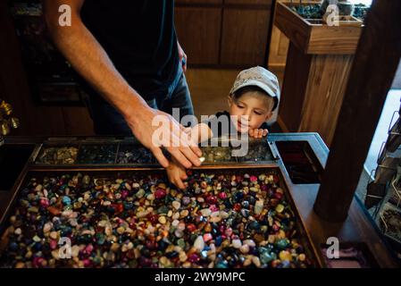 Dad und kleiner Junge schauen sich die Steine drinnen im Laden an Stockfoto