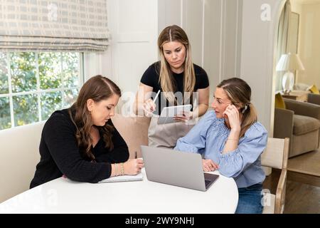 Eine Gruppe von Frauen in einem Team-Meeting, die in einem Heimbüro zusammenarbeiten Stockfoto