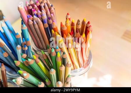 Gläser mit farbigen Bleistiften auf Holzschreibtisch - bunt - Kunstraum Stockfoto