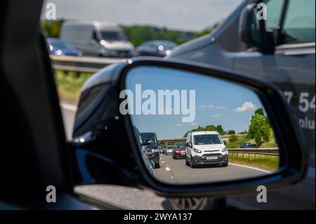 Die Warteschlange des Verkehrs wurde im Außenspiegel eines Autos auf der Autobahn M62 in England gesehen. Stockfoto