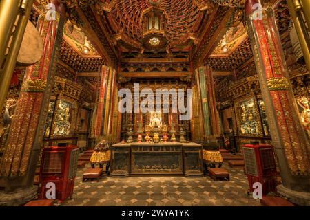 Ein aufwendig dekorierter Longshan-Tempel bei Nacht, gefüllt mit Blumen und goldenen Statuen Stockfoto