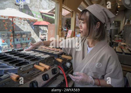 Ein lokaler Koch bereitet an einem belebten Street Food-Stand in Lukang traditionelle Pfannkuchen zu Stockfoto