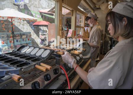 Ein lokaler Koch bereitet an einem belebten Street Food-Stand in Lukang traditionelle Pfannkuchen zu Stockfoto