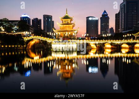 Guiyang, China - 09. Februar 2022: Der berühmte Jiaxiu-Turm und die Fuyu-Brücke spiegeln sich auf dem Fluss im Herzen des Stadtzentrums von Guiyang im Südwesten von C Stockfoto