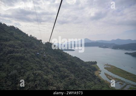 Seilbahnen hängen über dem Sun Moon Lake, umgeben von üppigen Wäldern und sanften Hügeln Stockfoto