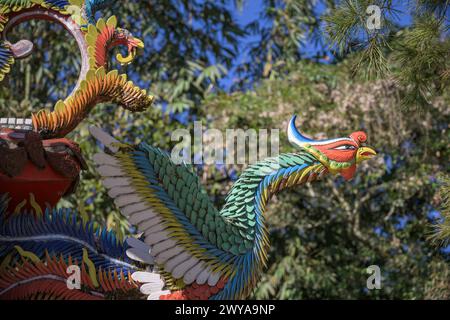 Eine lebendige Drachenskulptur auf einem Tempeldach mit blauem Himmel und Pinienholz Stockfoto