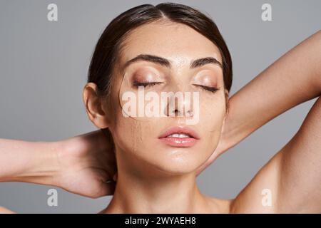 Eine junge Frau mit brünetten Haaren zeigt eine atemberaubende Schönheit in Augenflecken, geschlossenen Augen Stockfoto