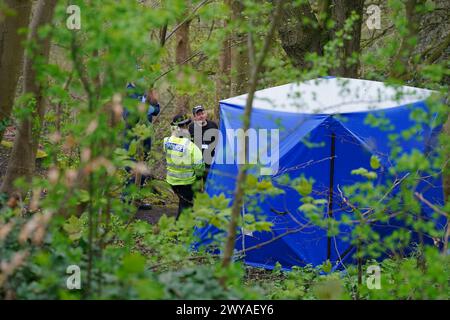 Polizeibeamte in einem forensischen Zelt in Kersal Dale, in der Nähe von Salford, Greater Manchester, wo eine große Untersuchung eingeleitet wurde, nachdem am Donnerstagabend menschliche Überreste gefunden wurden. Die Polizei von Greater Manchester (GMP) sagte, dass Beamte von einem Mitglied der Öffentlichkeit gerufen wurden, der einen „unbekannten Gegenstand in Plastik gewickelt“ fand. Bilddatum: Freitag, 5. April 2024. Stockfoto