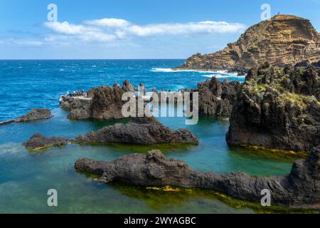 Touristen besuchen die natürlichen Meerwasser-Lava-Pools in Porto Moniz, Madeira, Portugal Stockfoto