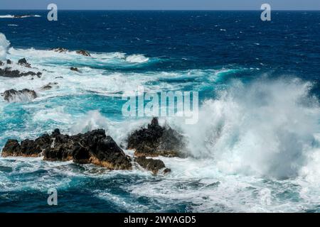 Lavasteine und Wellen in Porto Moniz, an der Küste der Insel Madeira, Portugal Stockfoto