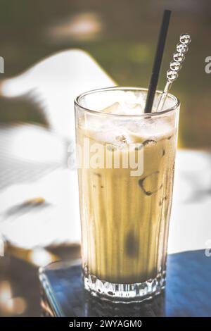 matcha Grüntee Latte serviert in einem hohen Glas mit Eis und Strohhalm Stockfoto