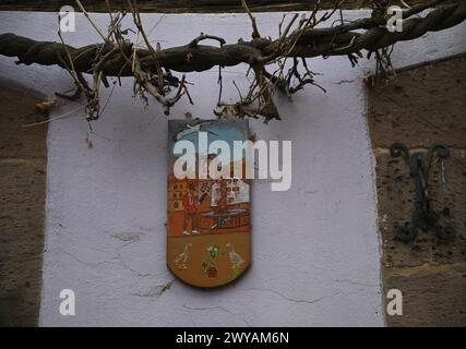 Antikes handgemaltes Straßenzeichen aus Holz an einer ländlichen Hauswand in Ribeauvillé, Frankreich. Stockfoto