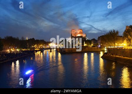 Dateifoto - Rauch und Flammen erheben sich am 15. April 2019 in Paris, Frankreich aus der Kathedrale Notre-Dame. Ein riesiges Feuer fegte durch das Dach der berühmten Kathedrale Notre-Dame in der französischen Hauptstadt und sandte Flammen und riesige Wolken aus grauem Rauch in den Himmel. Die Flammen und der Rauch stiegen vom Turm und dem Dach der gotischen Kathedrale auf, die jährlich von Millionen von Menschen besucht werden. - Am 15. April 2019 brach ein Feuer auf dem Dachboden von Notre-Dame de Paris aus, einer mittelalterlichen katholischen Kathedrale in Paris, Frankreich. Als das Feuer gelöscht wurde, war dieser Turm eingestürzt und der größte Teil des Daches war zerstört worden. Stockfoto