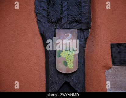 Antikes handgemaltes Straßenzeichen aus Holz an einer ländlichen Hauswand in Ribeauvillé, Frankreich. Stockfoto