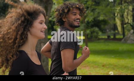 Fitness-Paar multirassische Kaukasierin und arabischer Mann laufen gemeinsam Outdoor-Workout Morgengewohnheit zwei Jogger Läufer Athleten joggen rein Stockfoto
