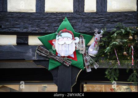 Festliche Weihnachtsdekoration am antiken Fenster eines Fachwerkhauses im Elsass Frankreich. Stockfoto
