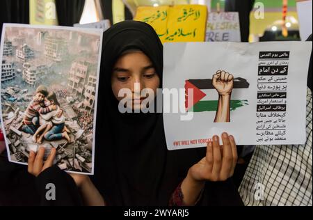 Srinagar, Indien. April 2024. Ein muslimisches Mädchen aus Kaschmir hält Plakate, die die Unterstützung Palästinas während einer Kundgebung zum Quds-Tag zeigen. (Al-Qud) ist der arabische Name für Jerusalem. Der Al Quds Day, eine Initiative des verstorbenen iranischen Revolutionsführers Ayatollah Ruhollah Khomeini, wird weltweit am letzten Freitag des Heiligen Monats Ramadan gefeiert, um die Unterstützung der Palästinenser zu zeigen und Israel zu verurteilen. Quelle: SOPA Images Limited/Alamy Live News Stockfoto