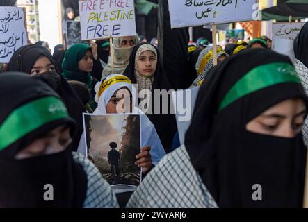 Srinagar, Indien. April 2024. Kaschmiri-muslimische Frauen halten Plakate, die die Unterstützung Palästinas während einer Kundgebung zum Quds-Tag in Srinagar zeigen. (Al-Qud) ist der arabische Name für Jerusalem. Der Al Quds Day, eine Initiative des verstorbenen iranischen Revolutionsführers Ayatollah Ruhollah Khomeini, wird weltweit am letzten Freitag des Heiligen Monats Ramadan gefeiert, um die Unterstützung der Palästinenser zu zeigen und Israel zu verurteilen. Quelle: SOPA Images Limited/Alamy Live News Stockfoto