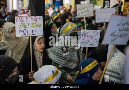 Srinagar, Indien. April 2024. Muslimische Frauen halten Plakate, die die Unterstützung Palästinas während einer Kundgebung anlässlich des Quds Day in Srinagars Außenbezirken zeigen. (Al-Qud) ist der arabische Name für Jerusalem. Der Al Quds Day, eine Initiative des verstorbenen iranischen Revolutionsführers Ayatollah Ruhollah Khomeini, wird weltweit am letzten Freitag des Heiligen Monats Ramadan gefeiert, um die Unterstützung der Palästinenser zu zeigen und Israel zu verurteilen. Quelle: SOPA Images Limited/Alamy Live News Stockfoto