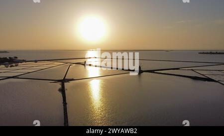 Aus der Vogelperspektive auf die Salinen von Stagnone und die alten Windmühlen bei Sonnenuntergang Stockfoto