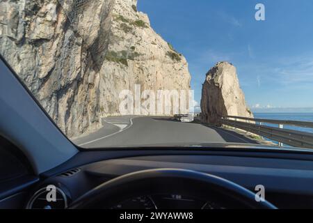 Aus dem Inneren des Autos die atemberaubende, hochgelegene Straße an den Klippen entlang der Küste von Ligurien, Italien Stockfoto