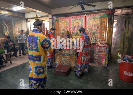 Ein traditioneller Schamane, der ein Ritual mit Opfergaben an die Vorfahren auf einem Altar im Donggyue Hall Tempel durchführt Stockfoto